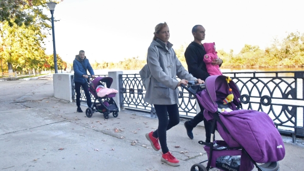 Родители с маленькими детьми гуляют по набережной в городе Энергодар1
