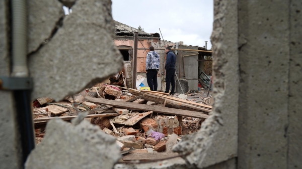 Люди возле дома, разрушенного в результате обстрела Донецка со стороны ВСУ0