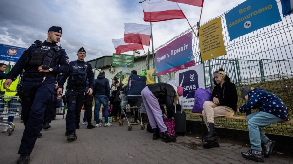 Польские полицейские проходят мимо украинских беженцев на контрольно-пропускном пункте Медыка — Шегини на польско-украинской границе1