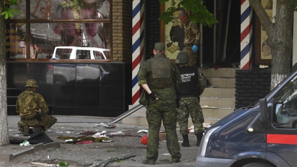 Сотрудники Следственного Комитета России и военные на месте взрыва в барбершопе в Луганске1